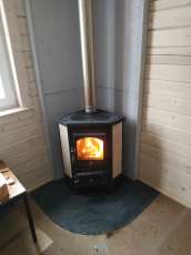 Недорогая печь-камин со стеклом Бавария угловая с плитой фото в интерьере в Мозыре